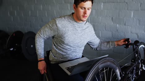 hombre discapacitado usando una computadora portátil mientras repara una silla de ruedas 4k
