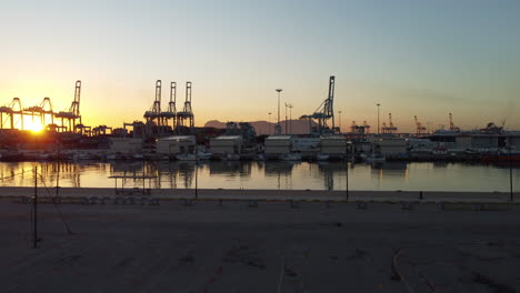 The-Rock-of-Gibraltar-rises-majestically-across-the-bustling-cargo-port-of-Algeciras,-its-shadow-stretching-over-towering-cranes-and-colorful-containers