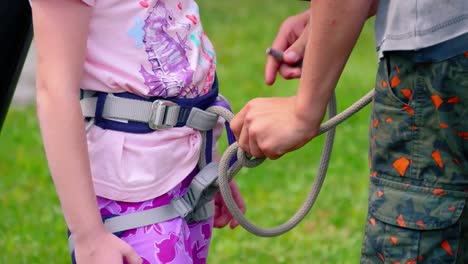 safety harness fall protection set on a little girl in pink t-shirt