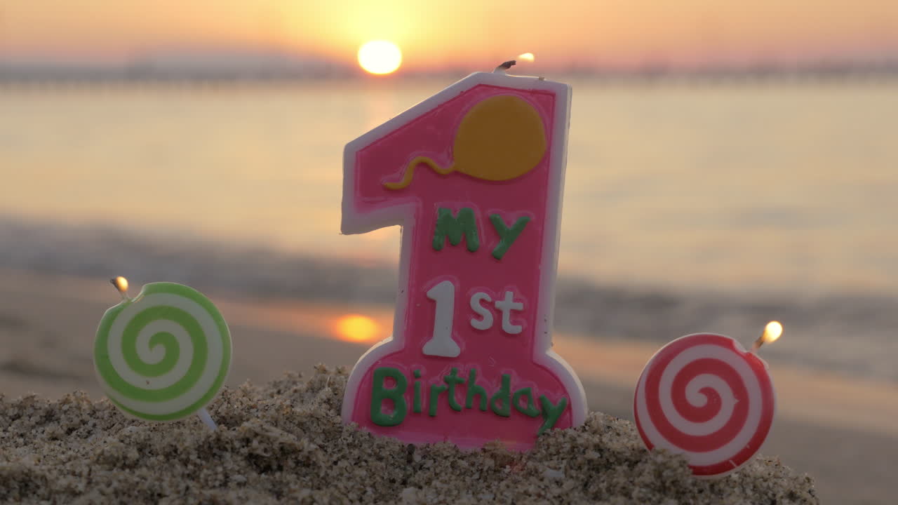 una vela de cumpleaños de un año en la playa
