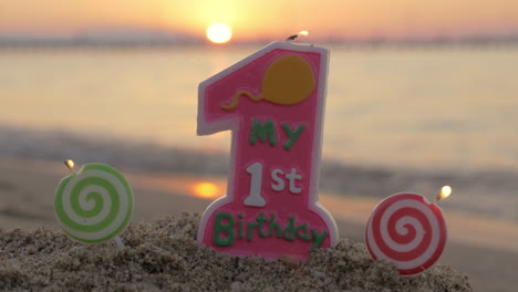 one year old birthday candle on the beach