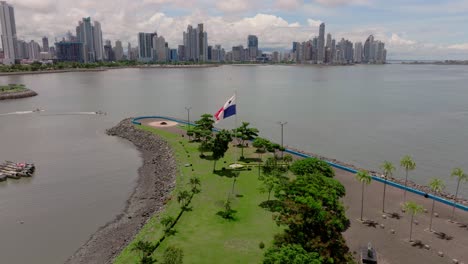 aerial orbit of panama flag with panama city and casco antiguo in the background