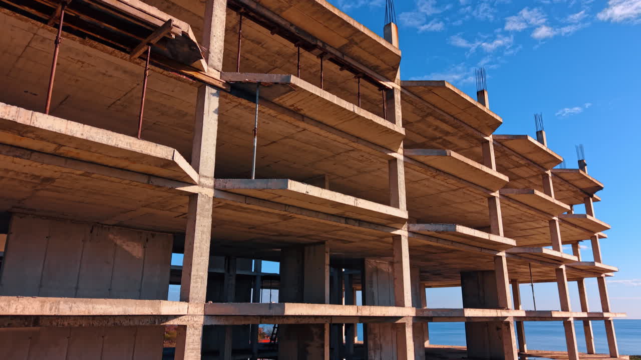 Betonnen skelet van het toekomstige gebouw met meerdere verdiepingen. Constructie zonder buitenmuren, vastgelegd met dronebeelden.