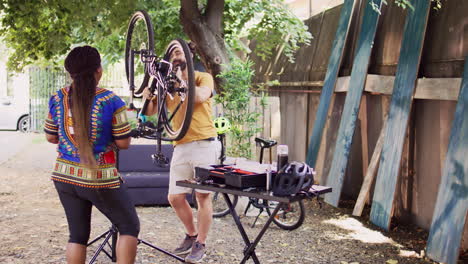 couple servicing modern bicycle in yard