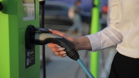 a video of a woman and a person charging their electric cars at a charging station, highlighting ecofriendly transportation options and the growing trend of electric vehicles