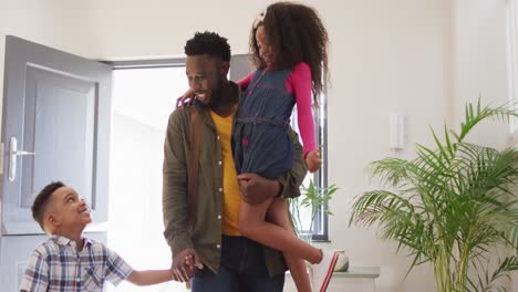 happy african american father coming back home and hugging with children