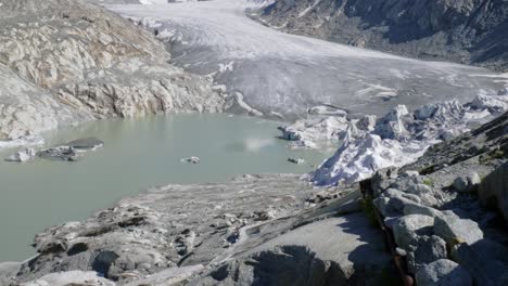 melted ice at bottom of rhone glacier in swiss alps, panning view