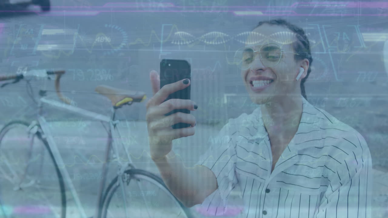 A biracial man with long dreadlocks is sitting in the street, using a smartphone and listening to