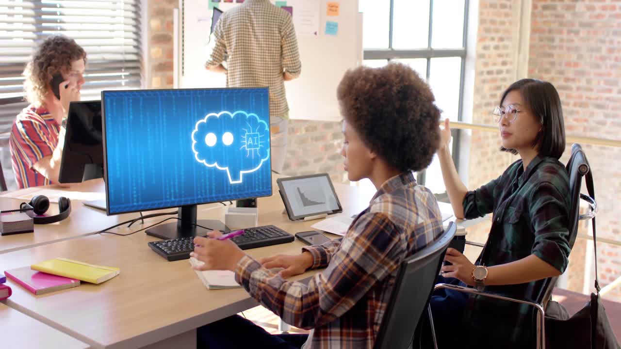 Diverse businesswomen in office using computer with ai interface on screen