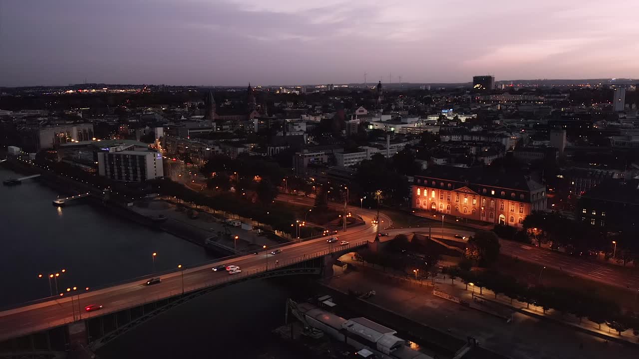 dejando una toma de la ciudad de mainz en alemania por la noche con un dron justo después de la hora mágica y la puesta de sol que muestra el puente viejo y el centro de la ciudad