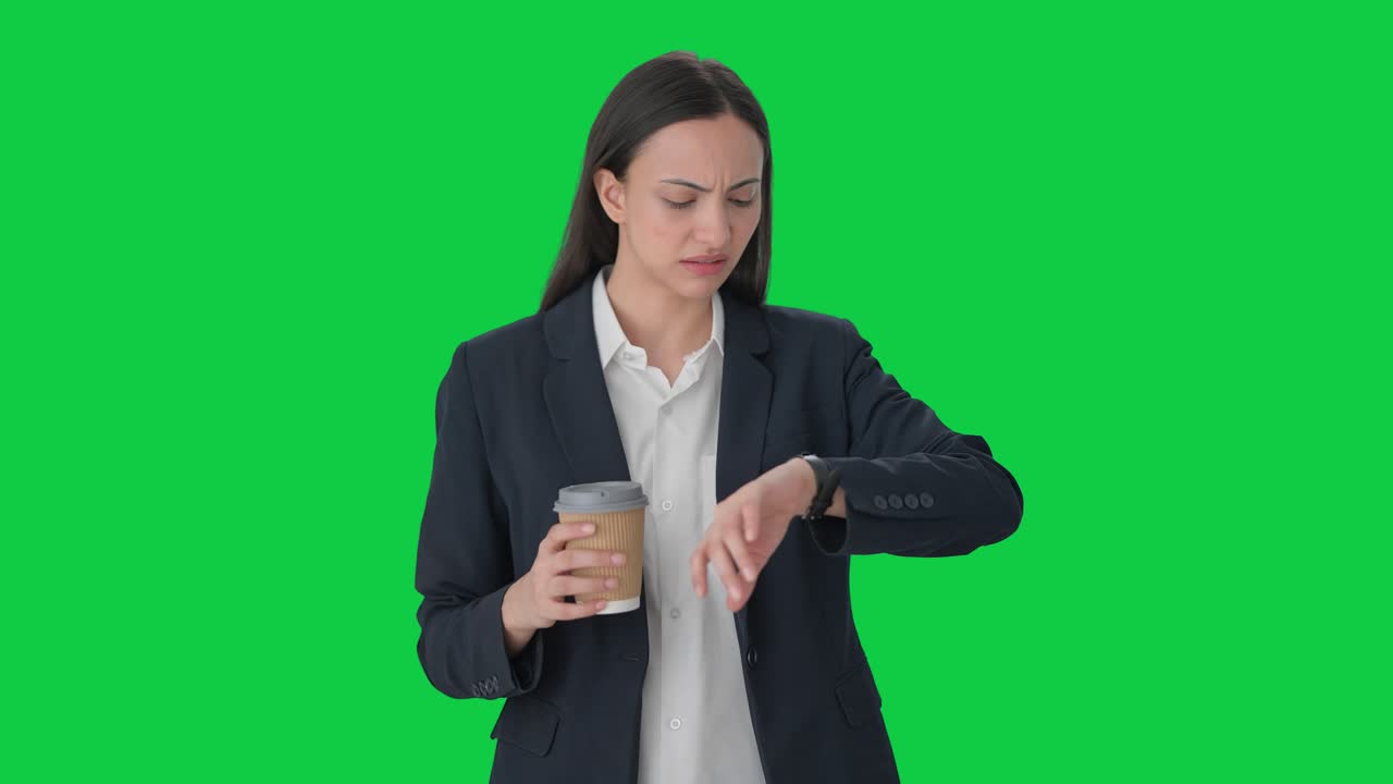 Indian female manager waiting for someone and drinking coffee Green screen