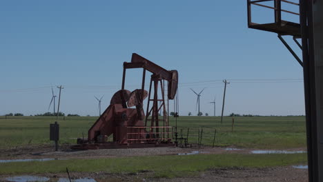 oklahoma - oil pump in green field with several turbines