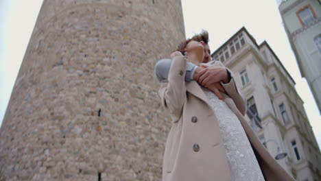 couple embracing near a historical tower