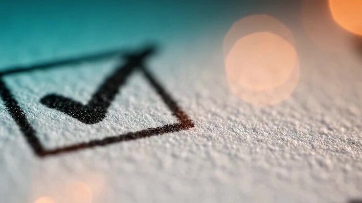 Close-Up of a Checked Box on Textured Paper Surface with a Subtle Glow Effect in the Background, Highlighting Success and Completion of a Task