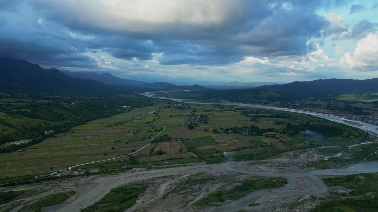A wide pull-out aerial in Bambang reveals rice fields encircled by the winding Santa Cruz River Bambang, Nueva Vizcaya, Philippines