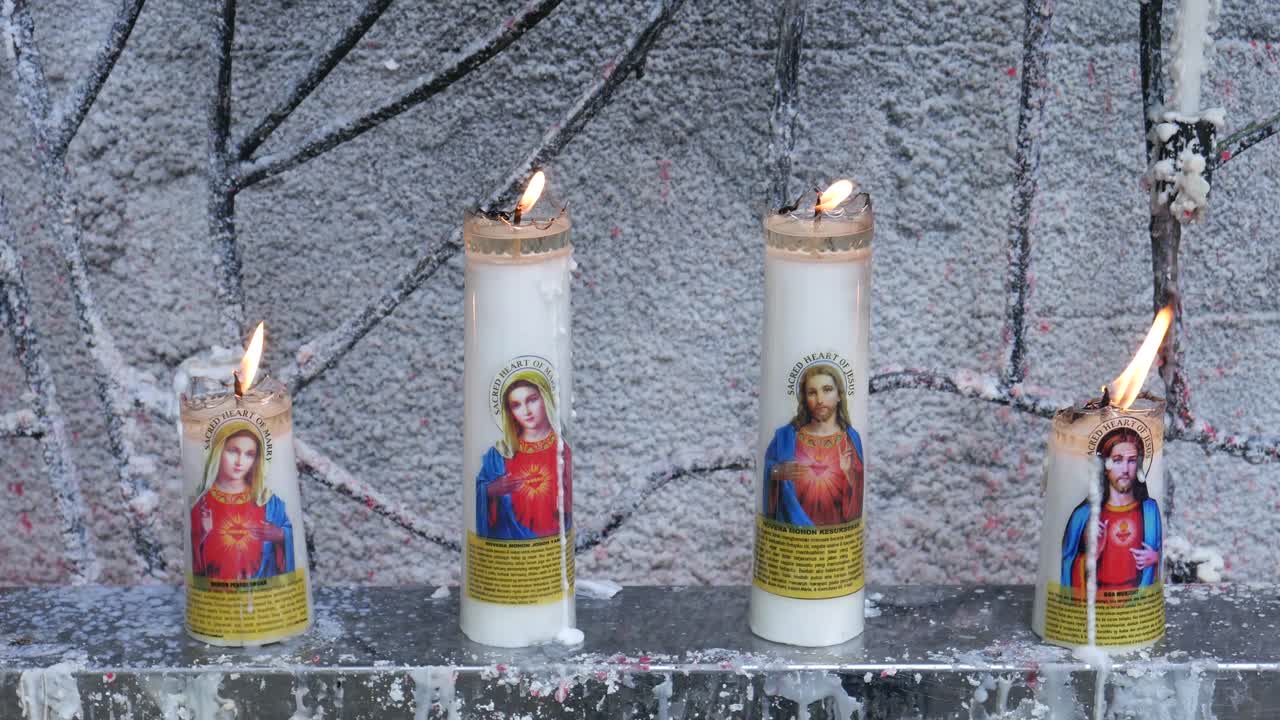 Yogyakarta, Indonesia - Feb 22, 2021 : Prayer candles with pictures of the Lord Jesus and the Mother of Mary at the shrine