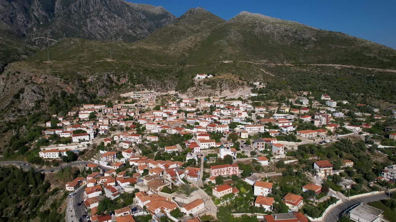 Mediterranean village of Dhermi in Albania, white houses, red roofs, cobblestone alleys on slope of mountains overlooking Ionian sea