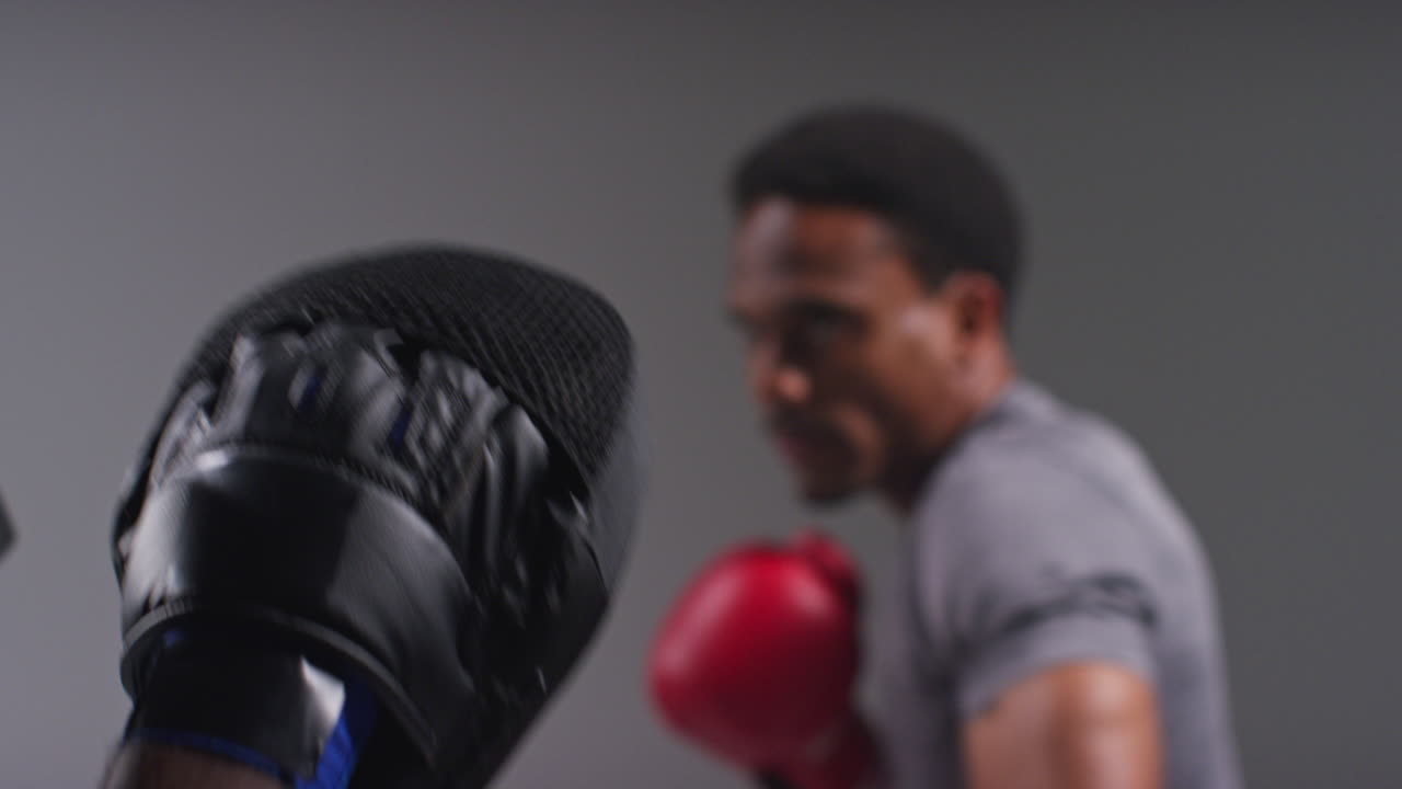 Close Up Shot Of Male Boxer Sparring Working Out With Trainer Wearing Punch Mitts Or Gloves Practising For Fight 2