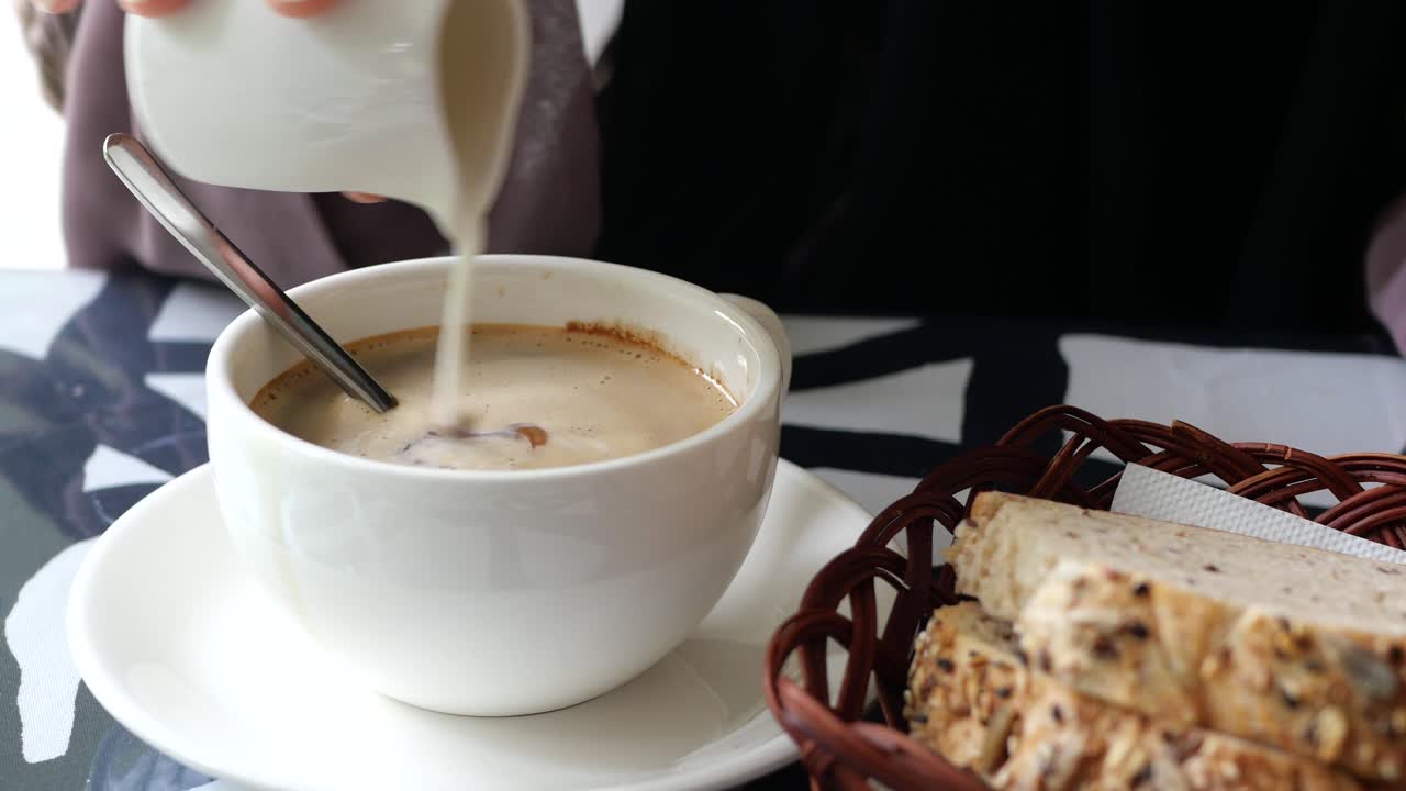 verter leche entera y azúcar en una taza de café
