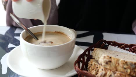 verter leche entera y azúcar en una taza de café