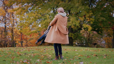 A-happy-mother-plays-with-the-baby-in-the-park,-holds-his-hands-and-circles.-Happy-Childhood-Concept