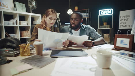 african american man and beautiful girl working with business reports in office.