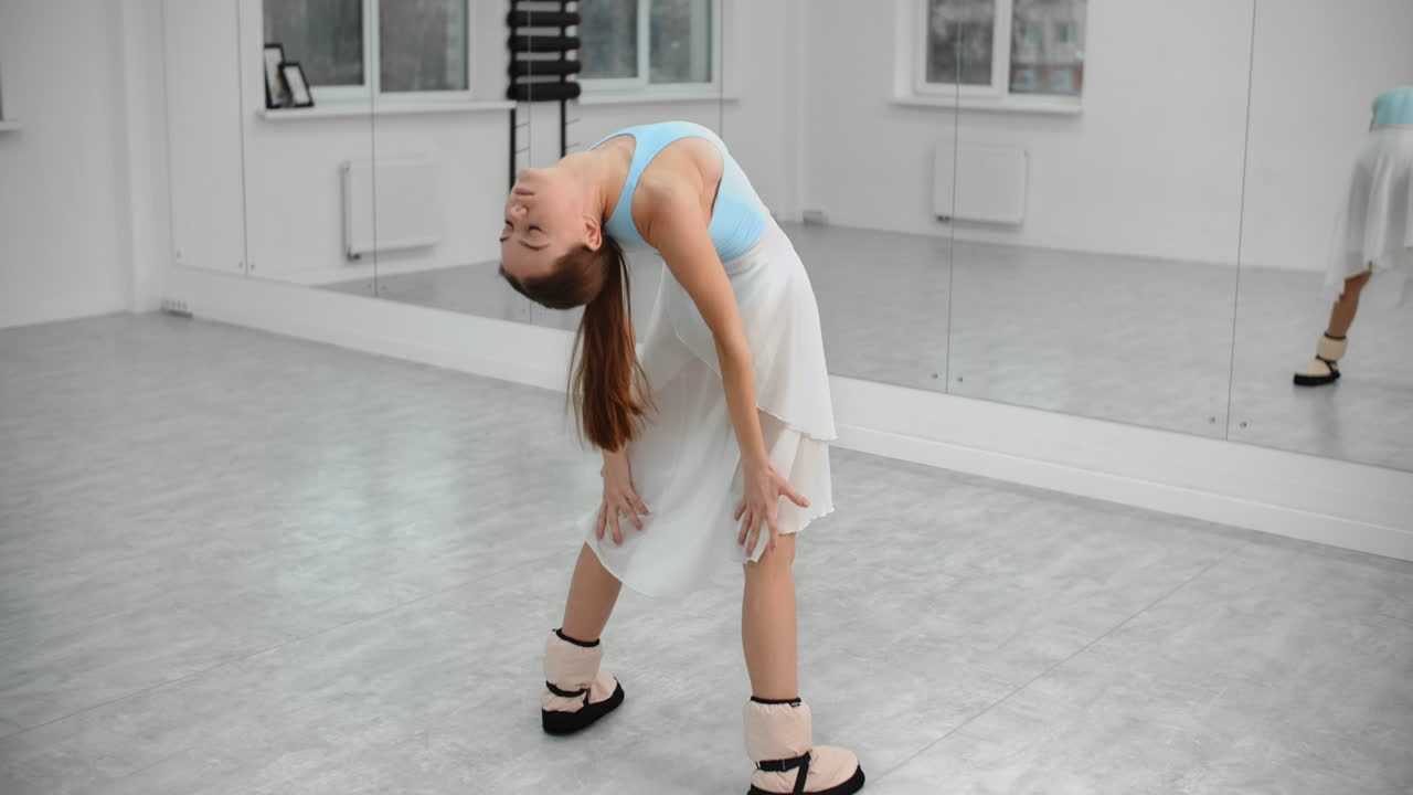 Ballet Dancer Stretching in Dance Studio