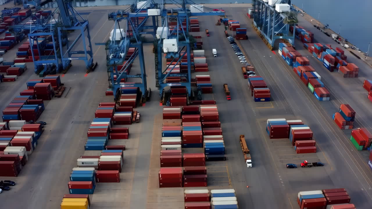Aerial View of a Bustling Shipping Port with Stacks of Containers and Cranes