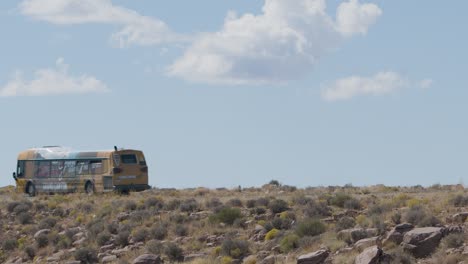 a grand canyon tour bus passes by and drives off out of frame.