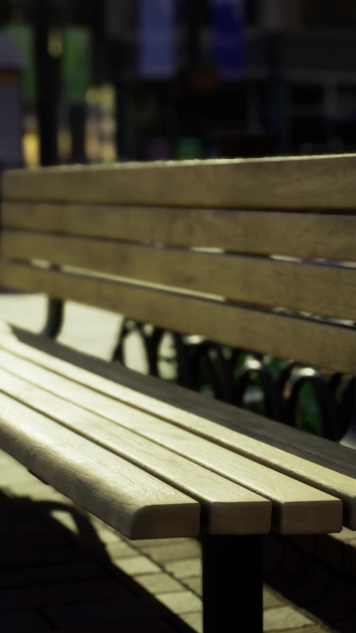 Wooden bench in urban area with sunlight shining in the afternoon