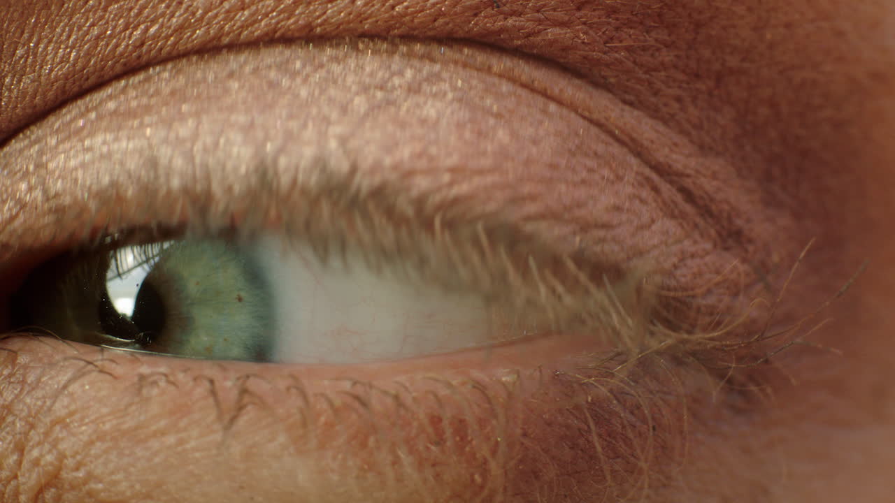 ojo macro de cerca mujer aplicando mascarilla de maquillaje