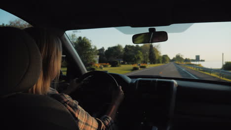 atractiva mujer de mediana edad conduciendo un coche en los suburbios americanos