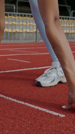 female runner in starting position on track