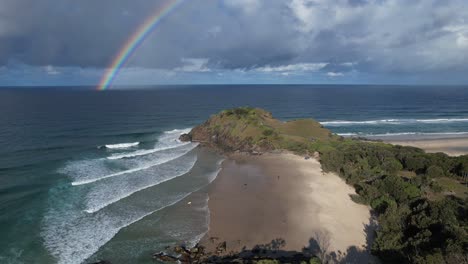 beautiful rainbow at norries headland and cabarita beach, new south wales, australia - aerial pullback