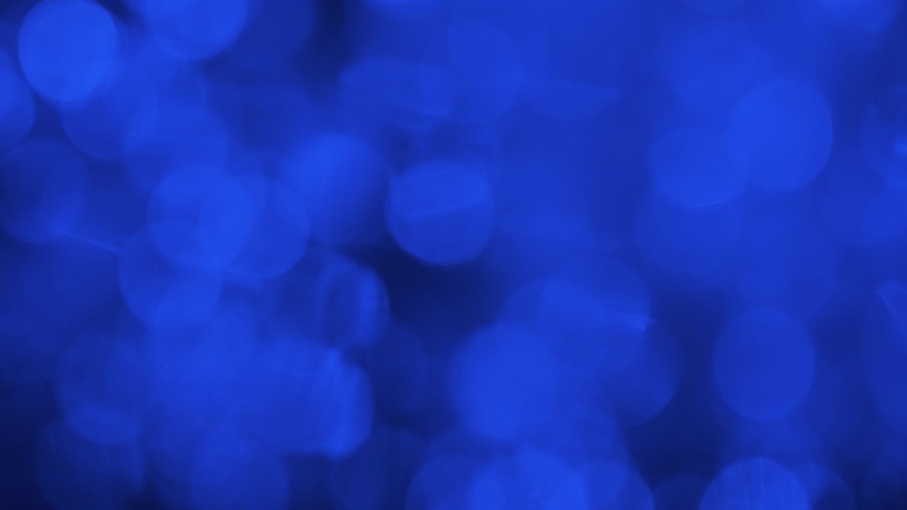 Drop falling into water and reflection of blue lights, blurry