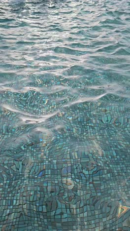 El-Agua-Cristalina-Crea-Suaves-Olas-En-La-Piscina-Con-Fuente,-Ofreciendo-Una-Vista-Serena.