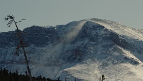 Winter-windstorm-blowing-drifting-snow-over-the-summit-of-a-mountain