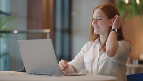 donna dai capelli rossi focalizzata insegnante a distanza tutor online indossare cuffie conferenza sul portatile comunicare con lo studente tramite webcam videochiamata chat spiegare corso aiuto e apprendimento concetto di istruzione informatica