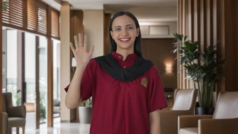 happy indian female housekeeper waving hello