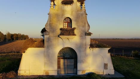 drone footage of the main façade of the hermitage of la señuela with nests of birds such as the stork