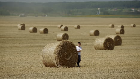 gelukkig kind op een veld met balen oogst