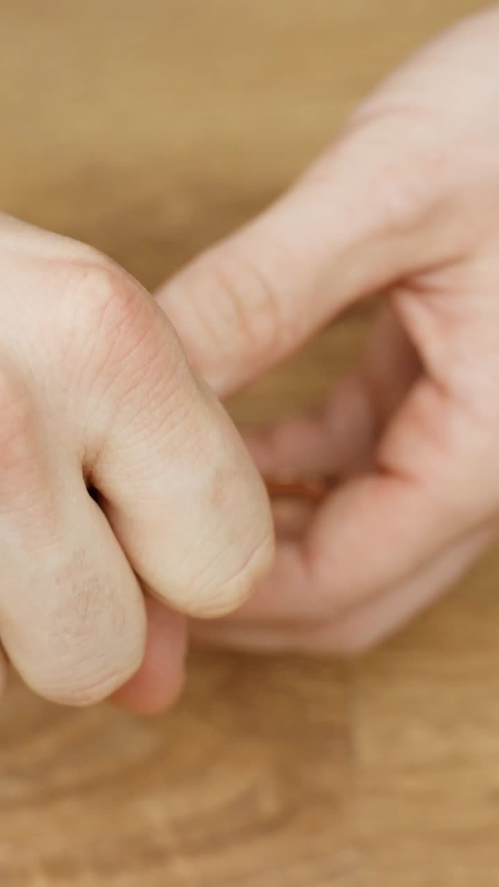 Close up of adult performing simple magic trick to make golden ring disappear using sleight hand illusion