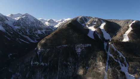 Drone-Cinemático-Aéreo-Desde-Arriba-Vista-De-La-Estación-De-Esquí-De-Montaña-De-Teluride-Senderos-De-Esquí-Colorado-Con-Paisaje-De-Montañas-Escénicas-Luz-Solar-Temprana-Mediados-De-Invierno-Pan-Al-Movimiento-Derecho