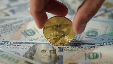 concepto de minería de bitcoin. mano humana girar bit de oro moneda en billetes de dólar