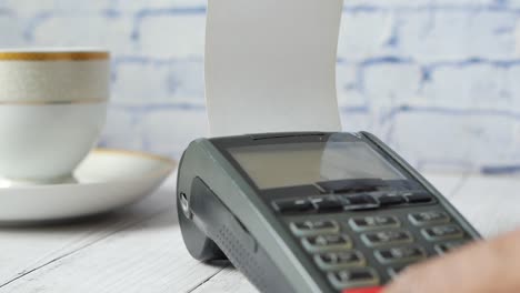 primer plano de una persona que utiliza una terminal de pago en un café