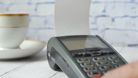 close-up of a person using a payment terminal in a cafe