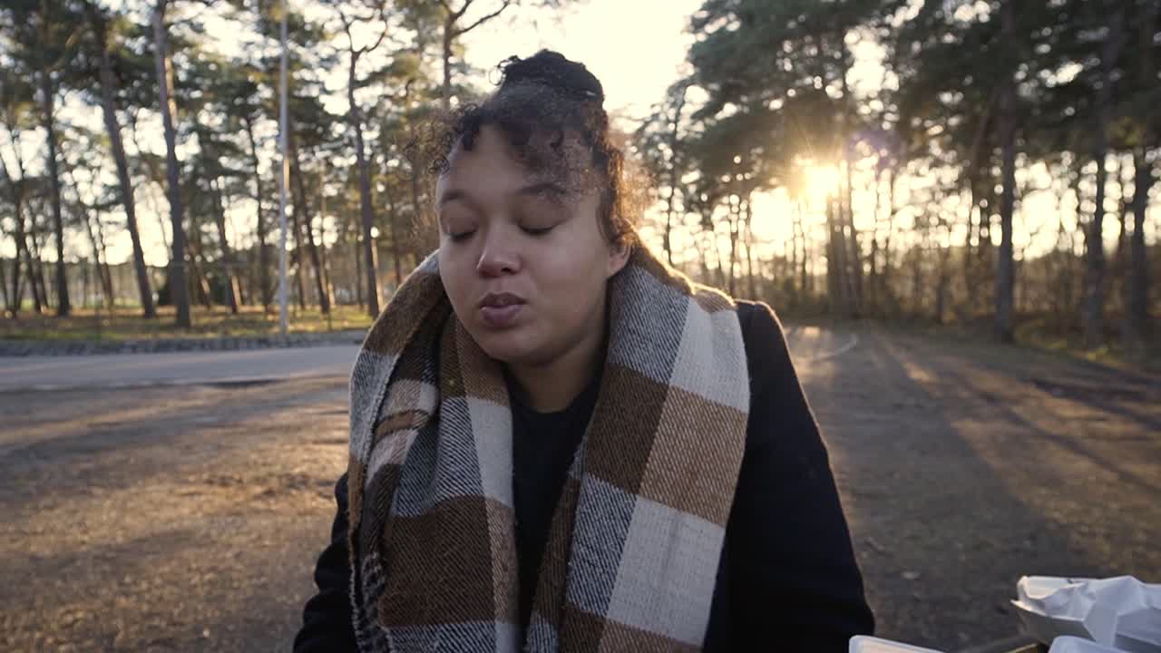 공원에서 픽닉으로 벨기에 감자튀김을 먹는 흑인 여성의 초상화