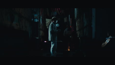 a man in hat in the empty gypsy circus camp at night