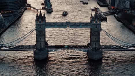 Stationäre-Drohnenansicht-Der-Tower-Bridge-Mit-Spiegelung-Des-Sonnenuntergangs-An-Der-Themse