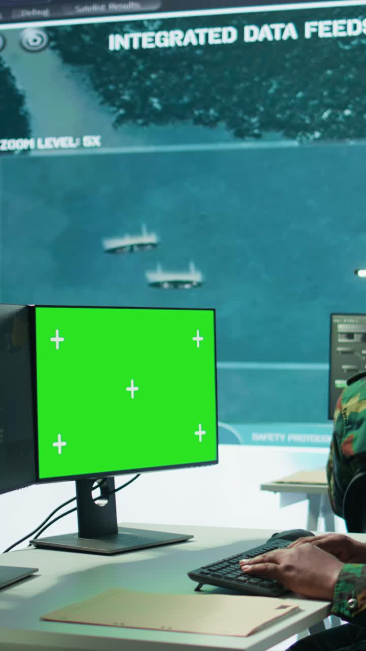 Vertical Video Military specialist monitors satellite data next to green screen display